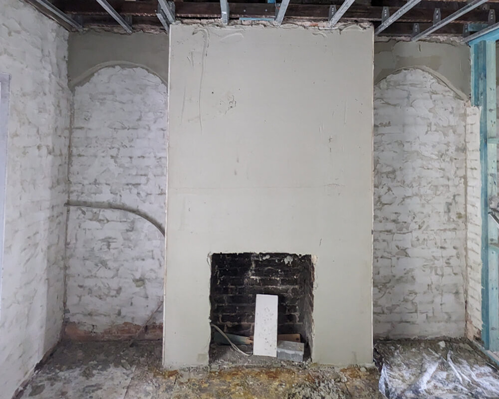 More coats over fireplace creating a smooth finish of render, interior of townhouse Erskineville, near Newtown